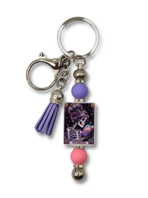 stylowy breloczek dla miłośników czytania z napisem Reader kobieta kościotrup czytająca książkę dodatki w kolorze fioletowym