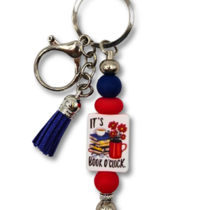 breloczek zawieszka na torebkę lub do kluczy dla miłośnika książki z napisem: It's book O'clock w kolorze czerwonym i granatowym