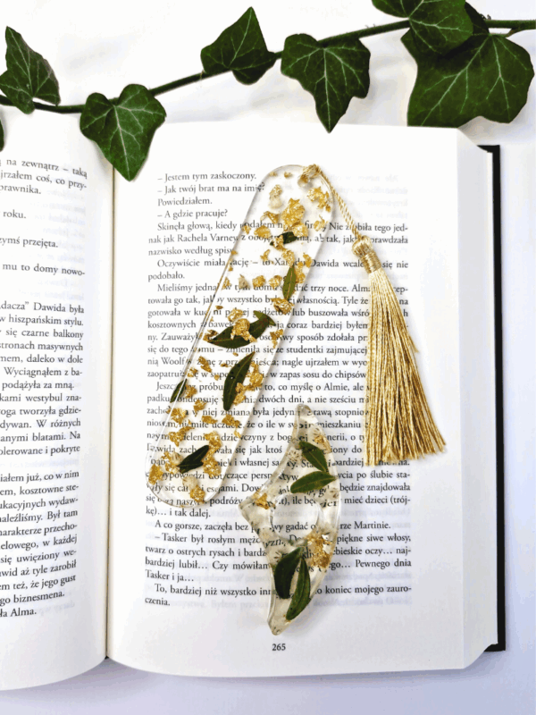 przeźroczysta zakładka z żywicy epoksydowej z zatopionymi listkami i kwiatkami gipsówki oraz uchwyt w tym samym stylu