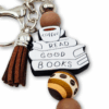 breloczek metalowy w kolorach kawy z motywem książek i kawy