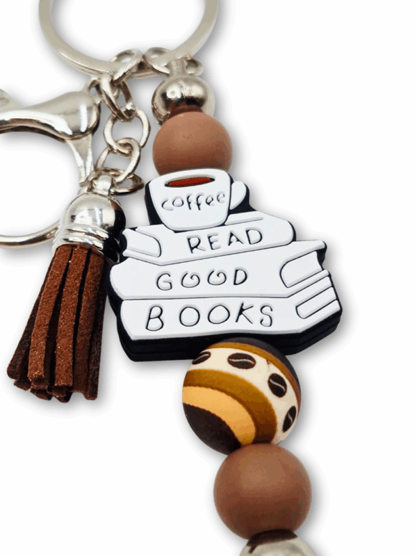 breloczek metalowy w kolorach kawy z motywem książek i kawy