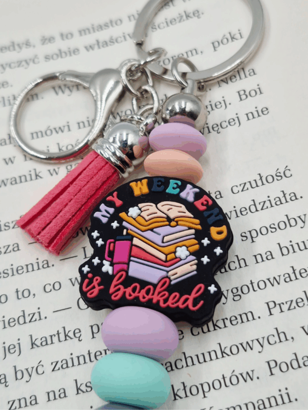 breloczek z motywem książkowym my weekend is booked kolorowy z frędzlem