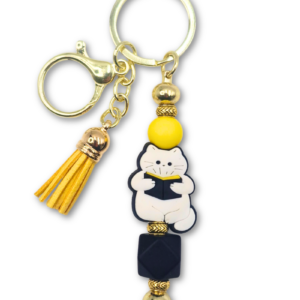 bag charm breloczek z kotem czytającym książkę w kolorze biało czarno żółtym dla miłośników białych kotów i czytania