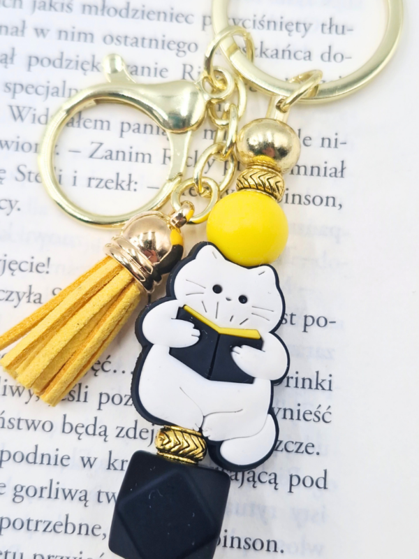 breloczek z czytającym kotem zabawny gadżet dla miłośników kotów i książek