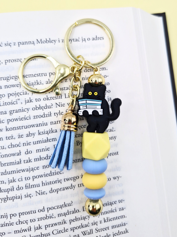 zabawny breloczek bag charm zawieszka do torebki pastelowa błękitna żółta z kotem z książkami prezent dla miłośniczki kotów i książek
