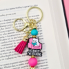 breloczek bag charm zabawny z tekstem go away i'm reading turkusowy i fuksja prezent dla miłośniczek kotów i książek